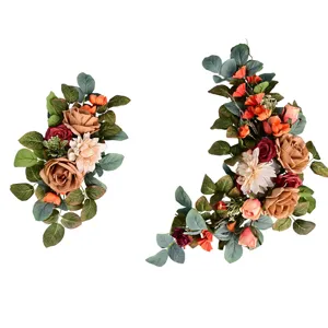 Vista dettagliata di due festoni di fiori artificiali arancione e bordeaux per matrimoni