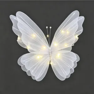Detailansicht eines weißen Schmetterlings aus Mesh mit warmen LED-Lichterketten zur Deko.