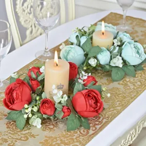 Detailed view of red and blue floral candle rings on an elegant gold table runner