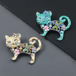 Primo piano di spille a forma di gatto in smalto vintage con fiori di strass