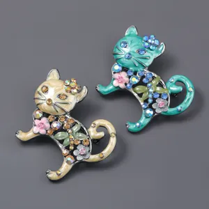 Primo piano dettagliato di spille vintage a forma di gatto in smalto con fiori di strass