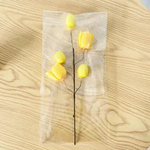 Close-up detail of yellow tulip Easter egg decorative flower branch in clear plastic bag