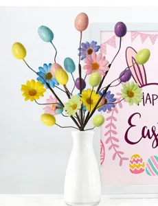 Close-up of Easter egg and daisy floral picks in a white vase decoration
