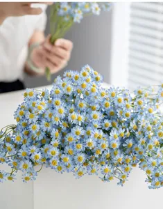Nahaufnahme des künstlichen blauen Gänseblümchen-Blumenstraußes für die Tischdeko.