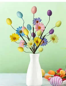 Detailed view of colorful Easter egg and daisy branches arranged in a white vase