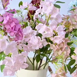 Close-up detail of artificial hydrangea bouquet in white vase, soft pink floral decor for home.