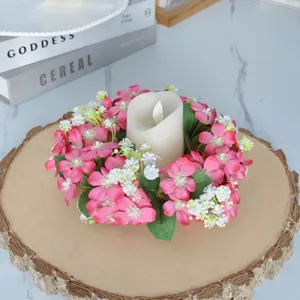 Vue détaillée de l'anneau de bougie floral rose avec bougie blanche sur bois, déco.
