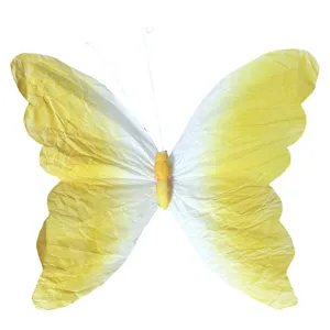 Gros plan détaillé de la décoration papillon en papier dégradé jaune et blanc et antennes.