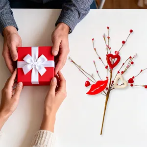 Valentinstag-Dekozweig mit roten Lippen und Herzen auf einer weißen Oberfläche