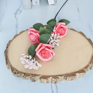 Primer plano de rosas artificiales rosas y flores de relleno sobre una rodaja de madera