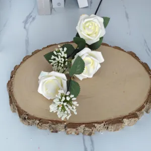 Vista detallada de rosas crema artificiales con frutos blancos de Milán en madera