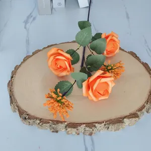 Detalle de rosas artificiales naranjas con bayas de Milán sobre una base de madera