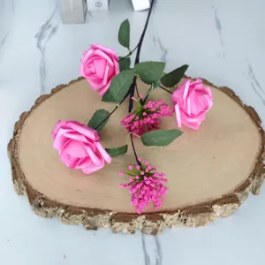 Rosas artificiales rosas y bayas de Milán en una rodaja de madera para decorar
