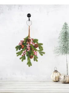 Artificial Christmas pine swag with natural pine cones and red berries on a white wall
