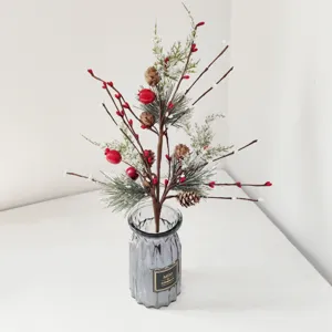 Festive artificial Christmas pine needle branch with red berries and snow-dusted pine cones.