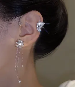 Vista detallada del elegante ear cuff giratorio de flor y mariposa con borlas brillantes