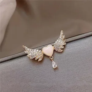 Detailed macro view of an elegant angel wing heart brooch with shell inlay and crystal drop