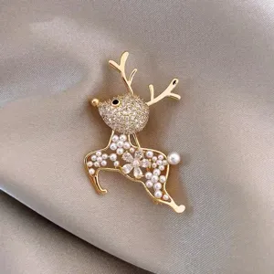 Macro view of exquisite golden reindeer brooch with pearl inlay and crystal flower detail