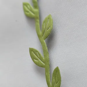 Macro detail of green fabric leaf vine for birthday banner decoration on white background