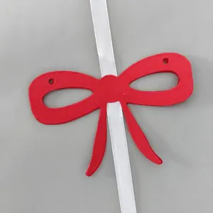 Close-up of a vibrant red paper bow banner component on a white decorative ribbon