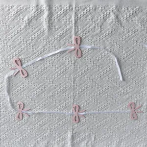 Detail view of pink bow paper garland with white ribbon for birthday party decoration