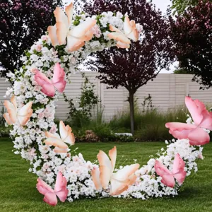 Decorative crescent floral wedding arch with large pink gradient PE butterflies in garden