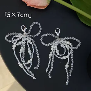 Detailed view of handmade pearl bow shoe charms with clear bead strands for DIY jewelry