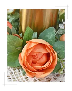 Close-up detail of realistic orange artificial peony flower on a floral candle ring