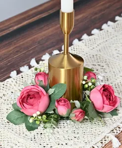 Close-up detail of romantic pink peony candle ring wreath decoration on a golden candlestick