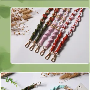 Close-up of Bohemian woven flower phone straps with diverse colors and gold lobster clasps.