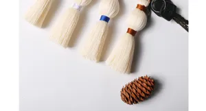 Handcrafted cotton woven tassel keychain and bag charm detail, featuring intricate knotting design.