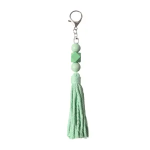 Portachiavi boho con perline in legno verde menta, nappa in cotone e gancio d'argento