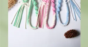 Close-up of handmade woven cotton rope pendants featuring colorful bow and flower motifs.