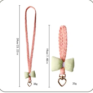 Detail of braided crossbody phone lanyard and wrist strap with heart clasp and bow