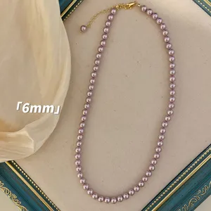 Nahaufnahme einer lila-rosa Perlenkette mit 6mm Perlen auf einem dekorativen Rahmen