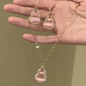 Close-up detail of the pink cat eye stone gourd necklace and earrings set in gold finish