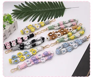 Close-up of colorful handmade braided daisy flower wrist straps for keys and phones.