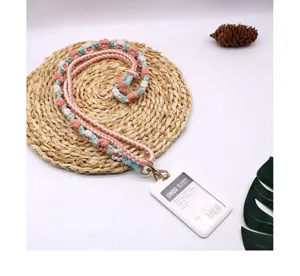 Detail of a handmade braided flower cotton lanyard with a white ID card holder and gold clasp.