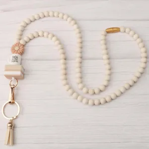Close-up detail of beaded lanyard showing silicone coffee cup charm, wooden beads, and tassel.
