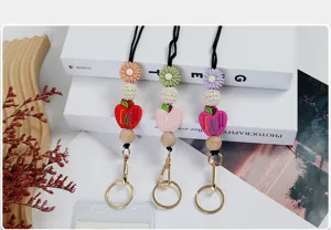 Detail shot of beaded teacher lanyards with TEACH apple charms and wooden beads