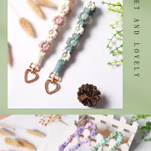 Macro view of hand-woven daisy flower wrist strap with faux pearl center and heart clasp