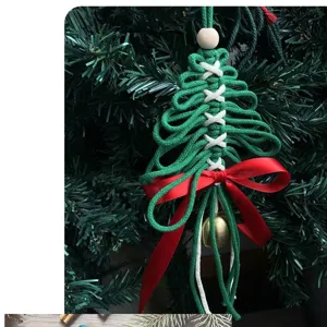 Gros plan d'une décoration de Noël tissée à la main avec un nœud rouge et une cloche.