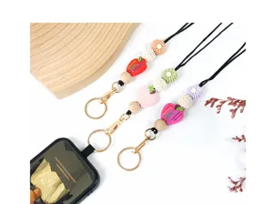 Close-up detail of handcrafted beaded lanyards with wooden beads and apple pendants