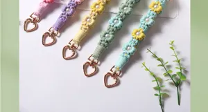 Close-up of hand-woven flower wrist straps with pearls and heart-shaped clasps