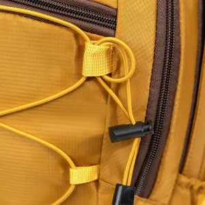 Macro detail of hiking backpack showing bungee cord lock and yellow ripstop fabric.
