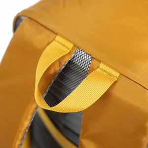 Close-up detail of lightweight yellow outdoor backpack showing handle and ripstop fabric texture