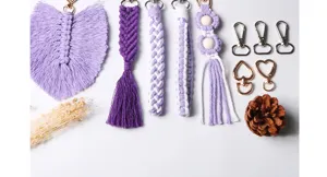 Dettaglio del materiale per portachiavi macramè fai da te, corde viola-bianche e moschettoni.