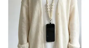 Gros plan sur le détail de la lanière de téléphone crochetée main avec de jolies marguerites.