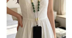 Handmade green and yellow woven phone lanyard strap displayed on a model wearing white dress