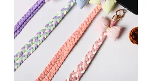 Close-up of braided macaron-colored phone lanyards with plush bow and heart clasp